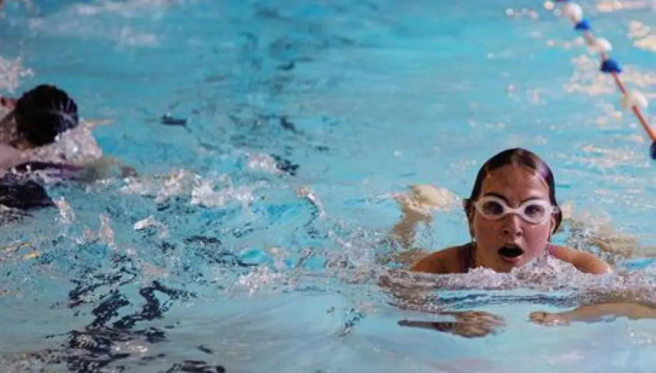 Several people swimming in the pool